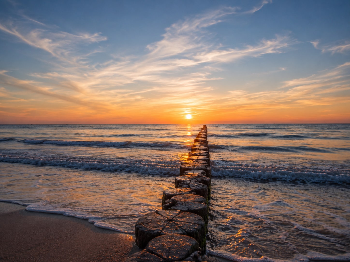 Sonnenuntergang über der Ostsee bei Dierhagen mit Buhnenreihe im flachen Wasser