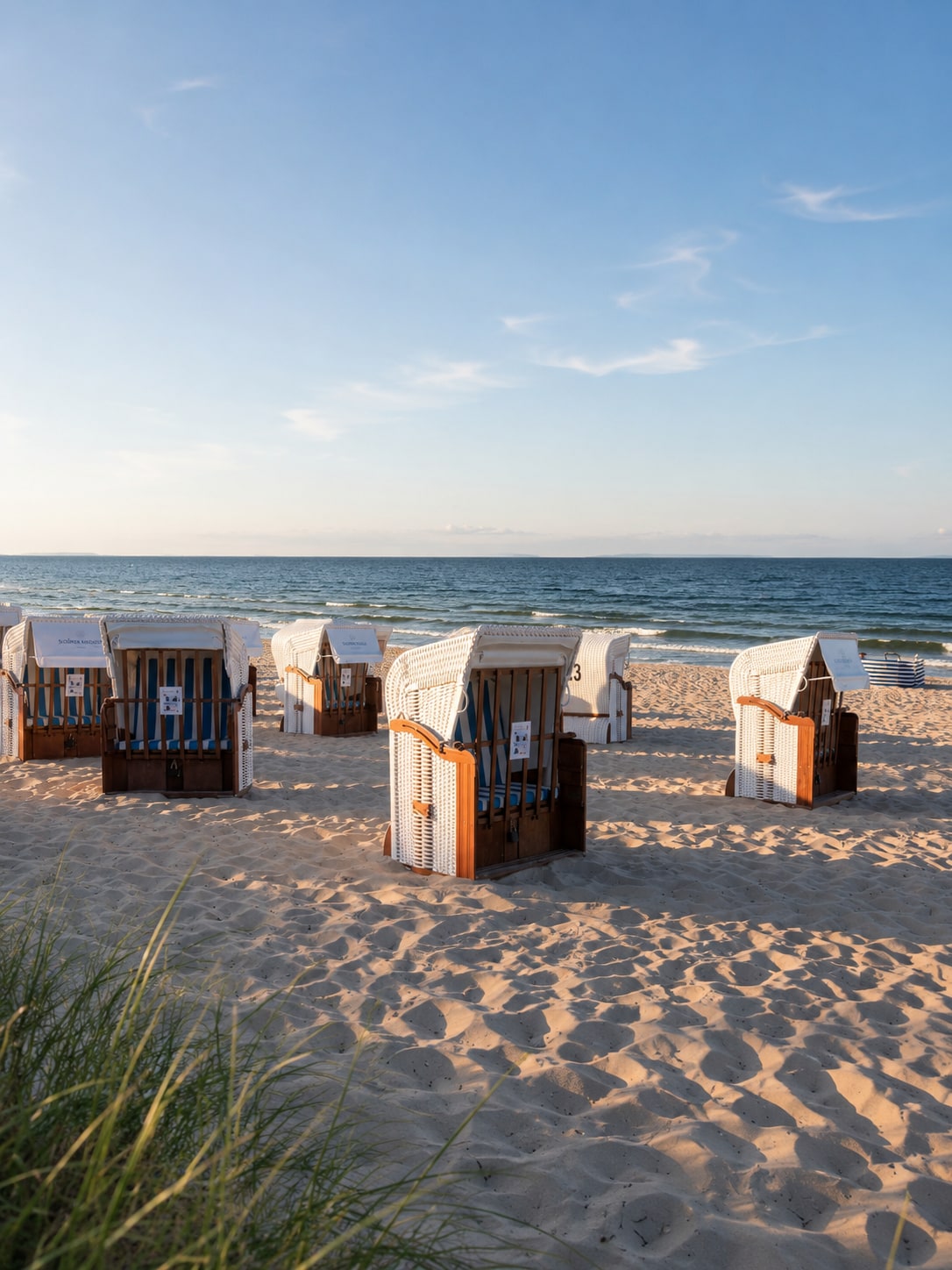 Strandkörbe am Morgen im Sand von Dierhagen, dahinter die ruhige Ostsee